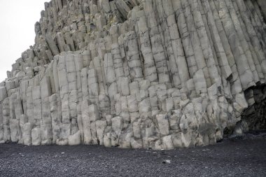 İzlanda 'nın güney kıyısındaki Reynisfjara' nın siyah kumsalındaki bazalt taşı sütunu.