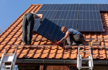 Ochojno, Polonya - 8 Nisan 2020: İşçiler Ochojno 'da bir evin çatısına güneş enerjisi panelleri kuruyorlar. Polonya