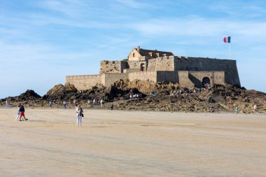 St. Malo, Fransa - 15 Eylül 2018: Saint Malo 'nun pitoresk plajında gün batımından önce insanların romantik yürüyüşü. Britanya, Fransa