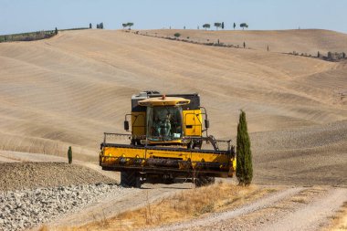 Pienza, İtalya - 13 Eylül 2011: Hasat sırasında hasat makinesini ve Toskana kırsalının manzarasını birleştirin. İtalya