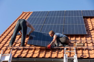 Ochojno, Polonya - 8 Nisan 2020: İşçiler Ochojno 'da bir evin çatısına güneş enerjisi panelleri kuruyorlar. Polonya