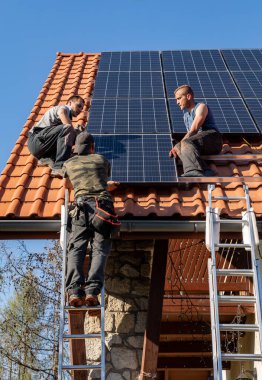Ochojno, Polonya - 8 Nisan 2020: İşçiler Ochojno 'da bir evin çatısına güneş enerjisi panelleri kuruyorlar. Polonya