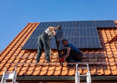 Ochojno, Polonya - 8 Nisan 2020: İşçiler Ochojno 'da bir evin çatısına güneş enerjisi panelleri kuruyorlar. Polonya