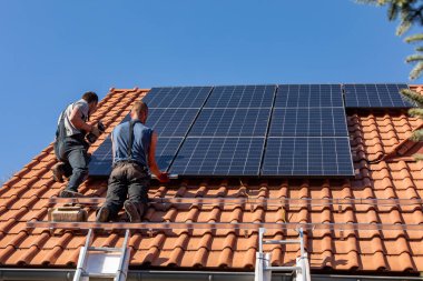 Ochojno, Polonya - 8 Nisan 2020: İşçiler Ochojno 'da bir evin çatısına güneş enerjisi panelleri kuruyorlar. Polonya