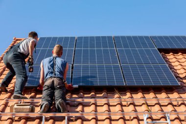 Ochojno, Polonya - 8 Nisan 2020: İşçiler Ochojno 'da bir evin çatısına güneş enerjisi panelleri kuruyorlar. Polonya
