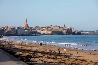 St. Malo, Fransa - 15 Eylül 2018: Saint Malo 'nun pitoresk plajında gün batımından önce insanların romantik yürüyüşü. Britanya, Fransa