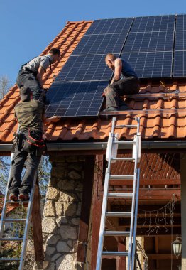 Ochojno, Polonya - 8 Nisan 2020: İşçiler Ochojno 'da bir evin çatısına güneş enerjisi panelleri kuruyorlar. Polonya