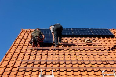 Ochojno, Polonya - 8 Nisan 2020: İşçiler Ochojno 'da bir evin çatısına güneş enerjisi panelleri kuruyorlar. Polonya