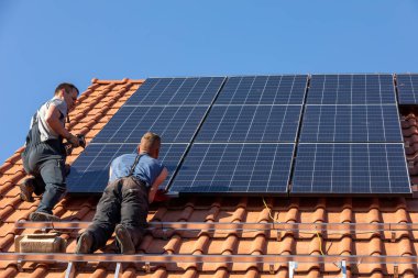 Ochojno, Polonya - 8 Nisan 2020: İşçiler Ochojno 'da bir evin çatısına güneş enerjisi panelleri kuruyorlar. Polonya