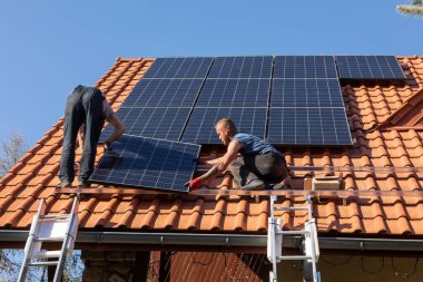 Ochojno, Polonya - 8 Nisan 2020: İşçiler Ochojno 'da bir evin çatısına güneş enerjisi panelleri kuruyorlar. Polonya