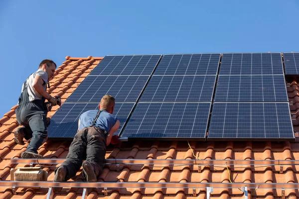 Ochojno, Polonya - 8 Nisan 2020: İşçiler Ochojno 'da bir evin çatısına güneş enerjisi panelleri kuruyorlar. Polonya