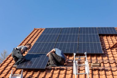 Ochojno, Polonya - 8 Nisan 2020: İşçiler Ochojno 'da bir evin çatısına güneş enerjisi panelleri kuruyorlar. Polonya