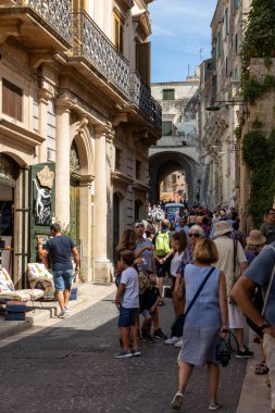 Matera, İtalya - 15 Eylül 2019: Matera şehrinin tarihi bir bölgesi olan Sassi di Matera 'daki Cobblestone caddesinde yürüyüş yapan turistler. Basilicata. İtalya