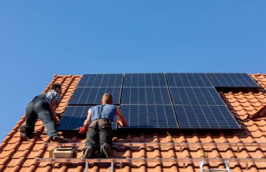 Ochojno, Polonya - 8 Nisan 2020: İşçiler Ochojno 'da bir evin çatısına güneş enerjisi panelleri kuruyorlar. Polonya