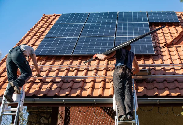 Ochojno, Polonya - 8 Nisan 2020: İşçiler Ochojno 'da bir evin çatısına güneş enerjisi panelleri kuruyorlar. Polonya