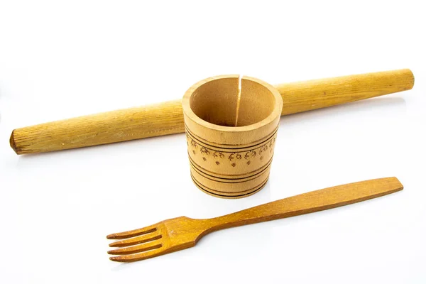 Three kitchen items made of wood. Finishing, a mortar with a pattern and a crack and a roller. Items on a white background.