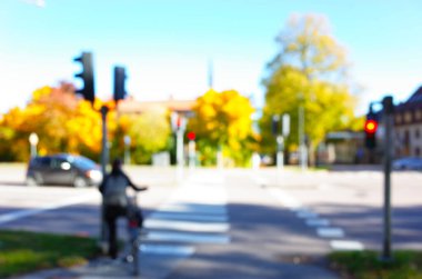 Yayaların kesiştiği caddenin bulanık fotoğrafı ve odak noktasından sarı sonbahar ağaçları, Bokeh arka planı.