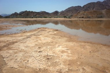 Fujairah, Birleşik Arap Emirlikleri 'nde çamur, su birikintisi ve kuru dağlarla çöl manzarası