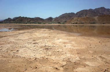 Fujairah, Birleşik Arap Emirlikleri 'nde çamur, su birikintisi ve kuru dağlarla çöl manzarası