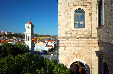 Pisagor, Samos Adası, Yunanistan - 13 Mayıs 2018: Ortodoks kilise duvarlı Lykourgos Logothetis 'in tepe ve saat kulesindeki Pythagorio kasabasının manzarası