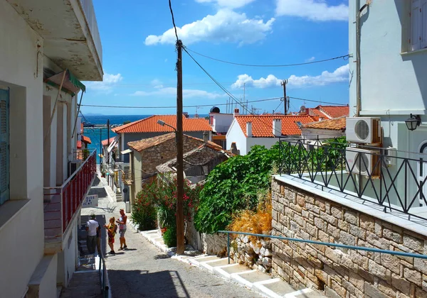 Pisagor, Samos Adası, Yunanistan - 12 Mayıs 2018: Güneşli bir günde geleneksel beyaz evler ve kırmızı çatılarla sokak manzarası