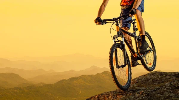 Cyclist Riding the Bike Down the Rock at Sunset. Extreme Sport and Enduro Biking Concept. — Stock Photo, Image