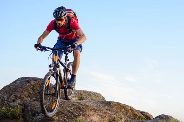 Cyklist i rött ridning cykeln nedför berget på blå himmel bakgrund. Extrem Sport och Enduro cykling koncept. — Stockfoto