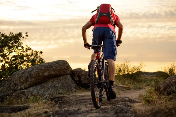 Cyklist i rött ridning cykeln på den steniga stigen vid solnedgången. Extrem Sport och Enduro cykling koncept. — Stockfoto