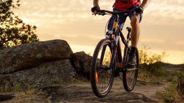 Bisikletçi kırmızı gün batımında kayalık iz üzerinde bisiklete binmek. Aşırı spor ve Enduro bisikleti kavramı. — Stok fotoğraf