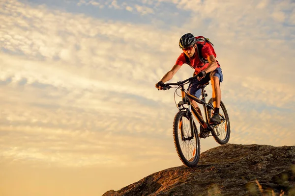 Kerékpáros piros a bringázás le a Rock a naplemente. Extrém Sport és Enduro biciklizés koncepció. — Stock Fotó