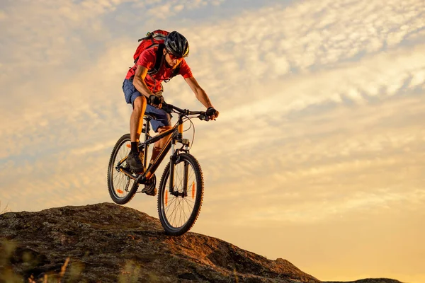 Велосипедист червоним їзді на велосипеді вниз скелі на заході сонця. Екстремальний вид спорту і ендуро їзди на велосипеді концепції. — стокове фото