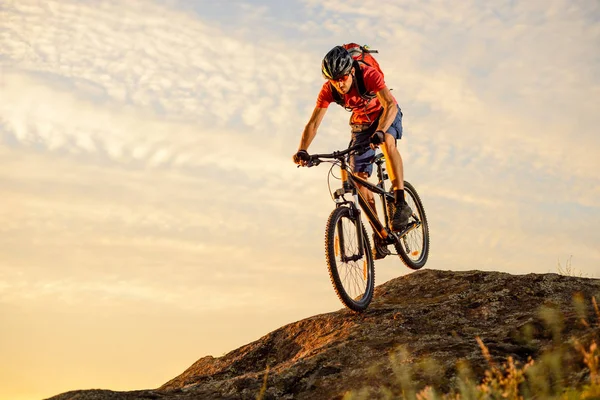 Kerékpáros piros a bringázás le a Rock a naplemente. Extrém Sport és Enduro biciklizés koncepció. — Stock Fotó