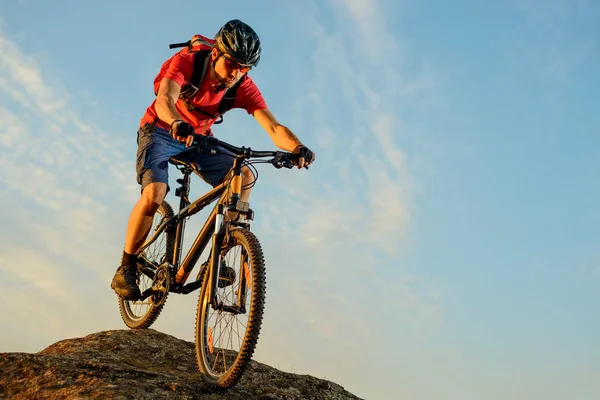 Ciclista em Red Riding the Bike Down the Rock no fundo do céu azul. Conceito de Ciclismo Extremo Esporte e Enduro . — Fotografia de Stock