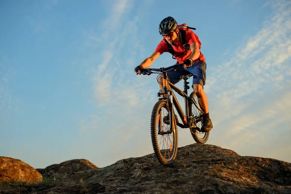 Cyclist in Red Riding the Bike Down the Rock on the Blue Sky Background (en inglés). Concepto de ciclismo extremo y enduro . — Foto de Stock