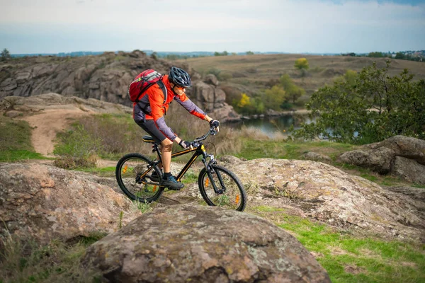 Wielrenner in het rood rijden de fiets op herfst rotsachtige Trail. Extreme Sport en Enduro fietsen Concept. — Stockfoto