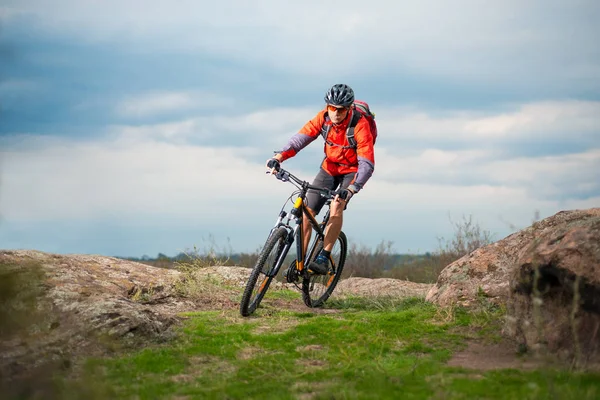 Radfahrer mit rotem Fahrrad auf dem steinigen Weg. Extremsport und Enduro-Konzept. — Stockfoto