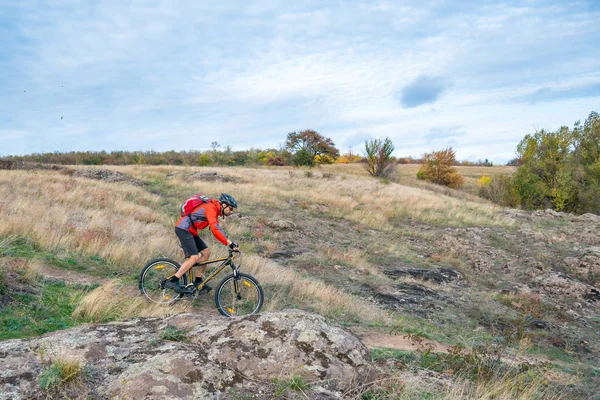 Bisikletçi Kırmızı Sonbahar Kayalık Yolda Binmek Aşırı Spor Enduro Bisikleti — Stok fotoğraf