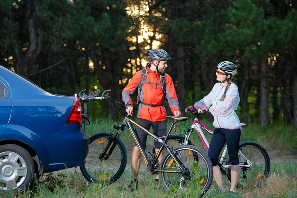 Young Couple Unmounting Mountain Bikes from Bike Rack on the Car. Adventure and Family Travel Concept. — Stock Photo, Image