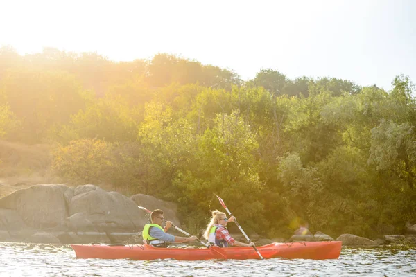 年轻幸福夫妇在美丽的河流或湖泊上划独木舟 — 图库照片