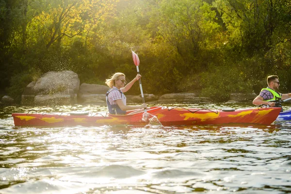 Genç mutlu çift kürek çekmeye Kayaks güzel nehir ya da göl üzerinde — Stok fotoğraf