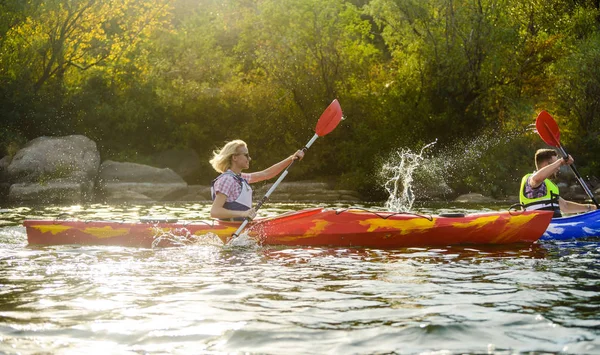 Junges glückliches Paar paddelt Kajaks auf wunderschönem Fluss oder See — Stockfoto