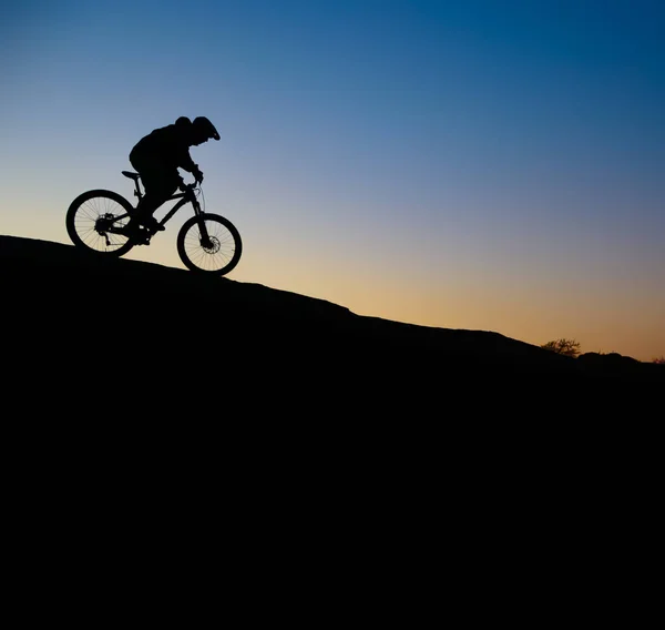 Radler auf felsigem Weg bei Sonnenuntergang. Extremsport und Enduro-Konzept. — Stockfoto