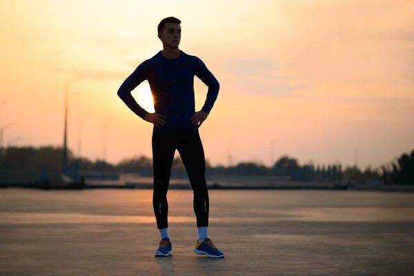 Молодий чоловік бігун відпочиває після бігу на заході сонця. здорового способу життя і спорту концепції . — стокове фото