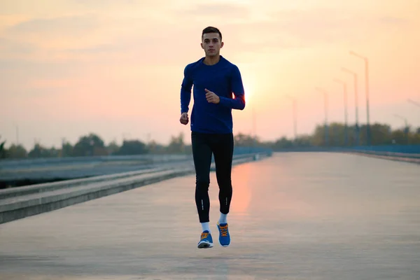 Joven deportista corriendo al atardecer. Concepto de estilo de vida saludable y deporte . —  Fotos de Stock