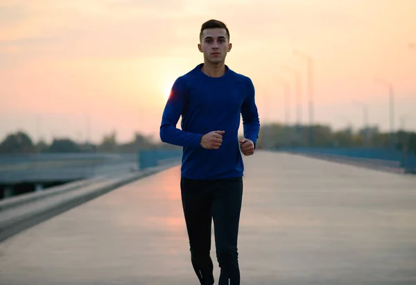 Joven deportista corriendo al atardecer. Concepto de estilo de vida saludable y deporte . —  Fotos de Stock