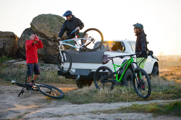 Przyjaciele biorąc Mtb rowery off Offroad pickupa w górach o zachodzie słońca. Przygoda i podróż koncepcja. — Zdjęcie stockowe