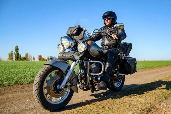 Motorrad-Fahrer fährt Custom-Chopper-Fahrrad auf Herbst Feldweg in der grünen Wiese. Erlebniskonzept. — Stockfoto