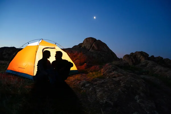 Çift oturma ışıklı çadır ve dağlarda Beautirul akşam birbirimize Looking — Stok fotoğraf