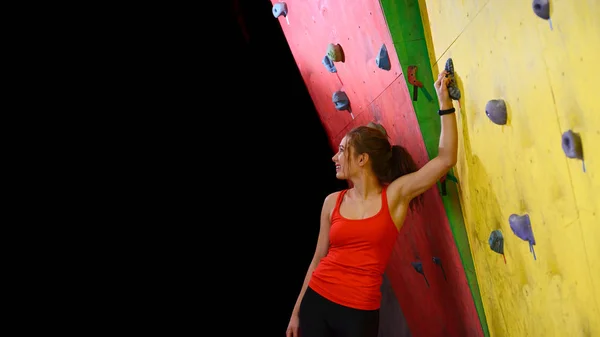 Fiatal aktív nő Boulder színes mesterséges rock tornaterem hegymászó. Extrém Sport és fedett hegymászó koncepció — Stock Fotó