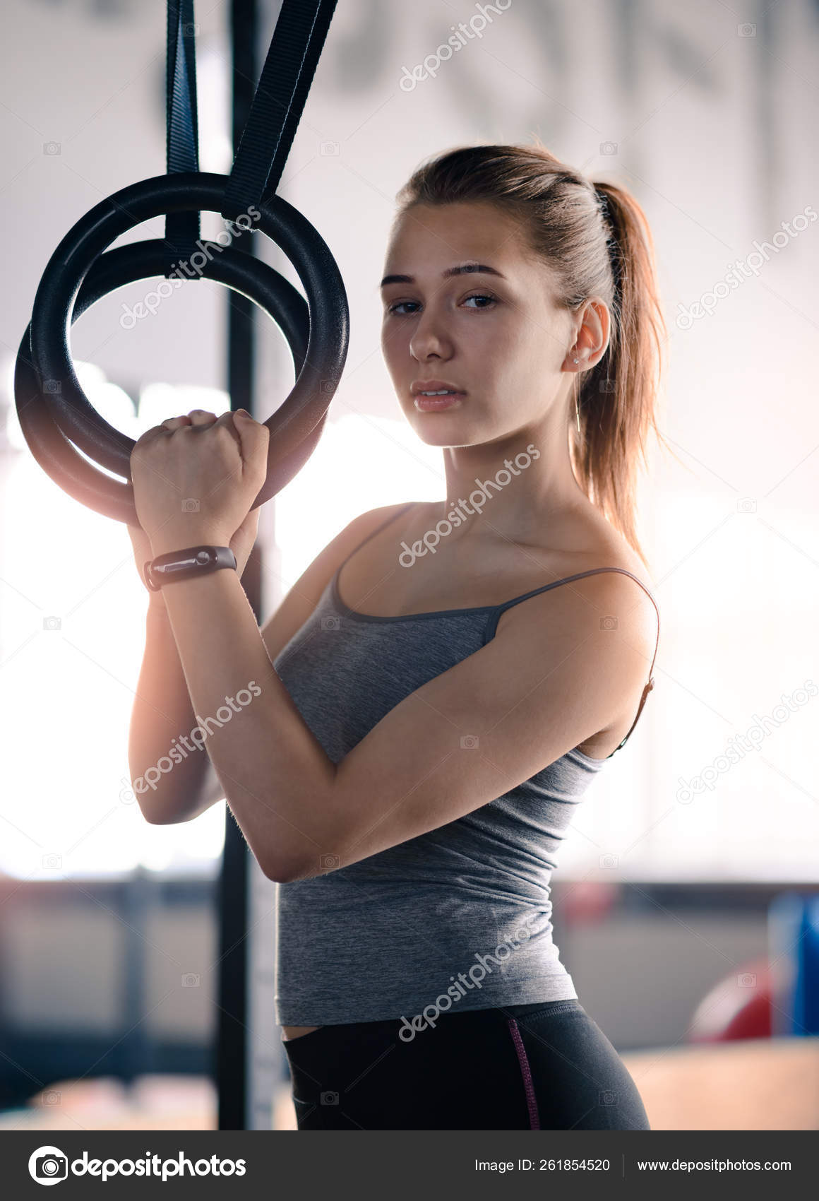 Woman using gymnastic rings in gym - Stock Photo - Dissolve